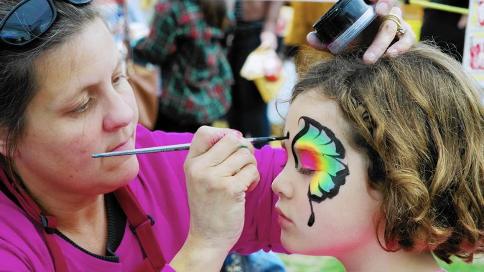 Woman Painting a Butterfly on a Girls Face